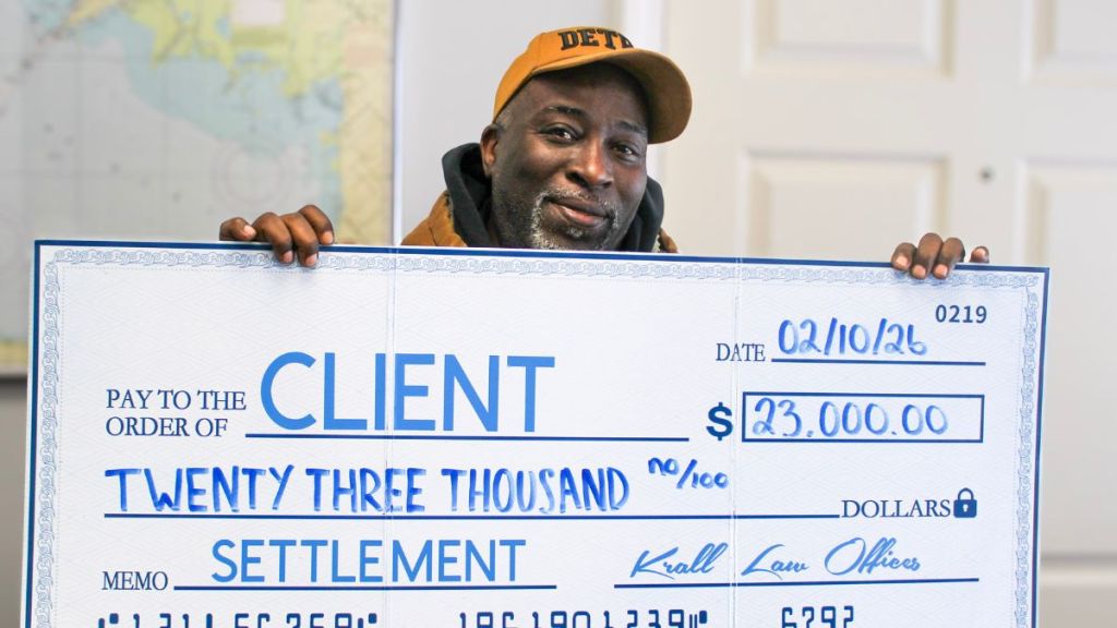 Client holding a check for twenty three thousand dollars