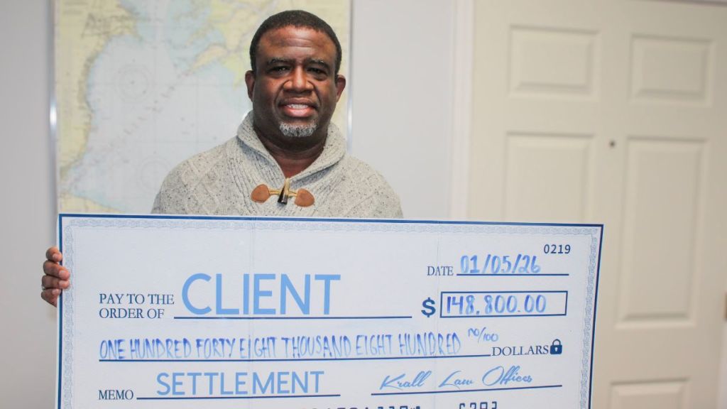Client holding a check for one hundred and forty eight thousand eight hundred dollars