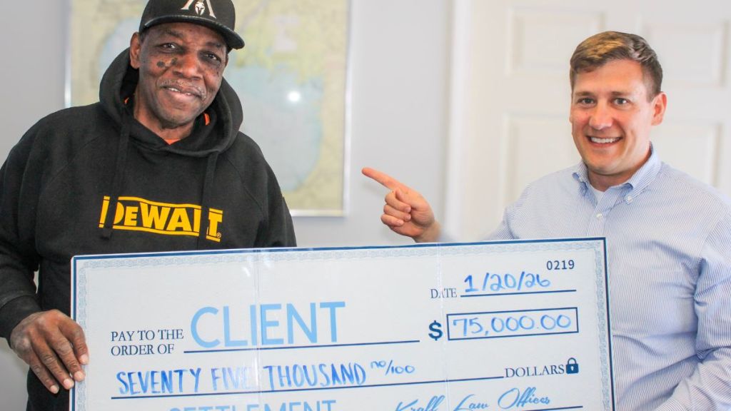 Client and attorney holding a check for seventy five thousand dollars