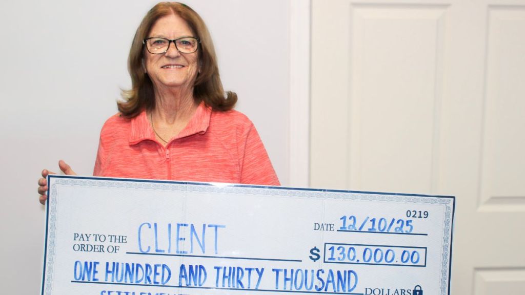 Client holding a check for one hundred thirty thousand dollars