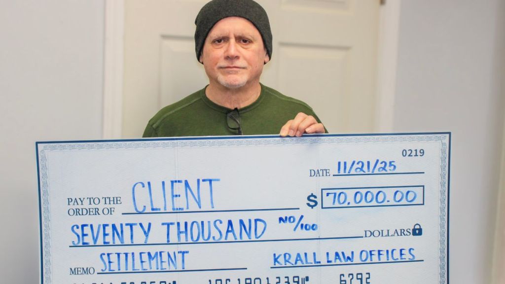 Client holding a check for seventy thousand dollars